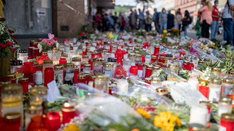 Grablichter, Kerzen und Blumen liegen vor einem Kaufhaus in der Innenstadt, in dem ein Mann am 25. Juni 2021 Menschen mit einem Messer attackiert und getötet hatte. Nun soll der Täter in einer Psychiatrie untergebracht werden.