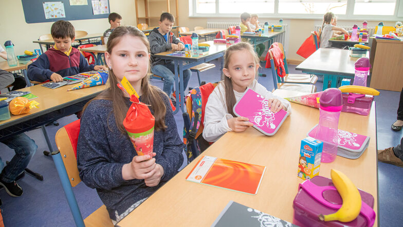Evelina und Alyna zeigen die Zuckertüte und Federmappe, die die ukrainischen Kinder als Geschenk von den Eltern der deutschen Grundschüler in Niesky bekommen haben.