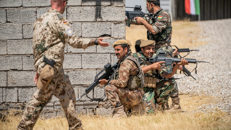 Ein Bundeswehr Soldat (l) begleitet auf dem Truppenübungsplatz in Bnaslawa die Ausbildung kurdischer Peschmerga im nordirakischen Kurdengebiet. 
