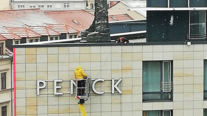 Arbeiter montieren den neuen Schriftzug ans Penck-Hotel.