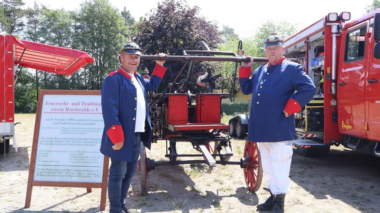 Arne Tschepel (li.) und Ulrich Vanatko vom Feuerwehr-und Traditionsverein Reichwalde haben ihr Herz an die alte Handdruckspritze von 1912 verloren.