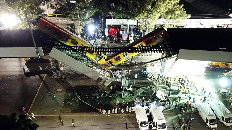 Blick auf den Unfallort vor dem Rettungskräfte stehen nachdem ein Brückenabschnitt der U-Bahn-Linie 12 in Mexiko-Stadt zusammengebrochen ist und mehrere Bahn-Waggons in die Tiefe stürzten.