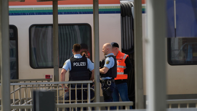 Bahnbedienstete und Polizeibeamte stehen am Bahnhof in Niederlahnstein vor einem Zug. In der Regionalbahn hat es einen Messerangriff auf einen Fahrgast gegeben, der schwer verletzt wurde.