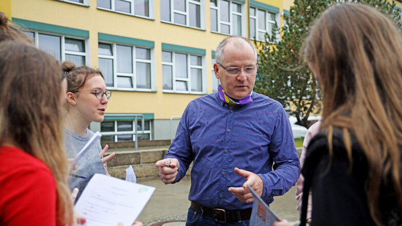 Praxisberater Gerd Wetteborn spricht mit Schülerinnen während der ersten länderübergreifenden Berufsmesse an der Gröditzer Oberschule.