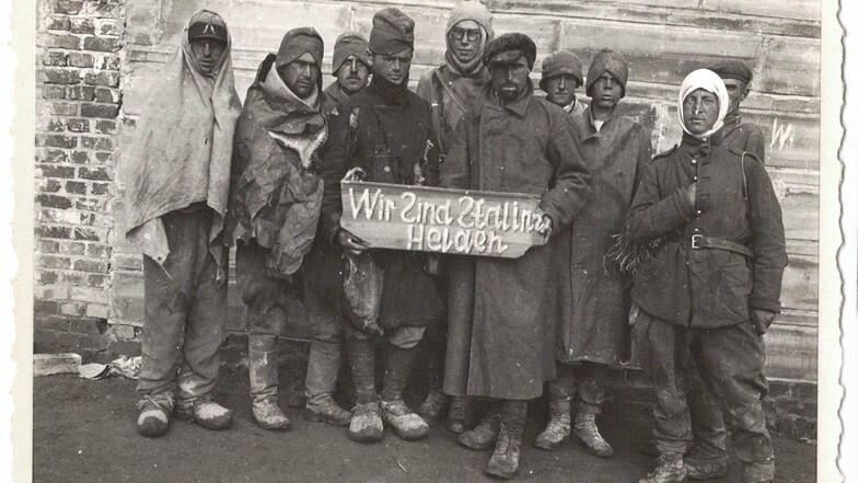 "Wir sind Stalins Helden" - mit diesem Schild wurden sowjetische Häftlinge im Kriegsgefangenenlager Zeithain inszeniert. Auffällig: die drei "S"-Buchstaben sind spiegelbildlich verkehrt abgebildet.