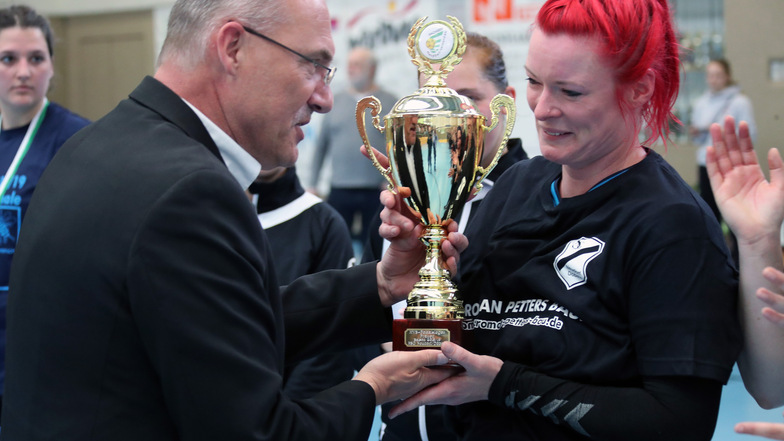 Uwe Vetterlein, Präsident des Handballverbandes Sachsen, übergibt der Neudorf/Döbelner HSG-Spielerin Judith Claassen den Sachsenpokal.