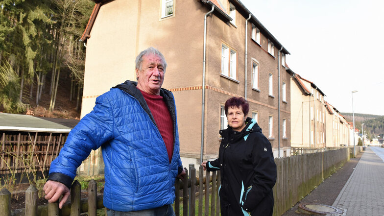 Der ehemalige Ortsvorsteher Peter Hofmann und Gisela Kerndt stehen hier vor den kommunalen Wohnhäusern in der Pöbeltalstraße in Schmiedeberg, die nun doch nicht verkauft werden sollen.