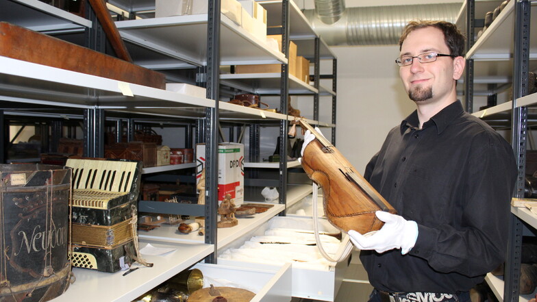 Museologe Alexander Polk zeigt eine historische Geige aus der Instrumentensammlung des Sorbischen Museums in Bautzen. Auch sie hat nun einen neuen Platz im Zentraldepot.
