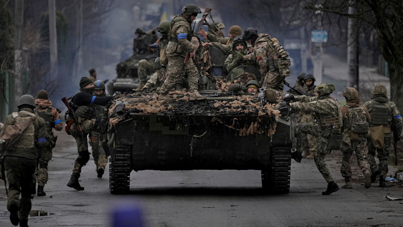 Ukrainische Soldaten klettern auf ein Militärfahrzeug