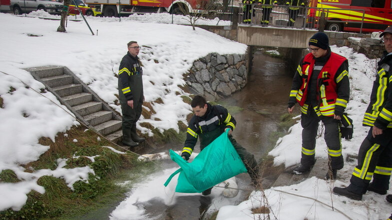 Mit Bindemittel und Ölsperren gingen Feuerwehrleute am Mittwochnachmittag gegen einen Ölfilm auf dem Schwarzwasser in Schmölln vor.