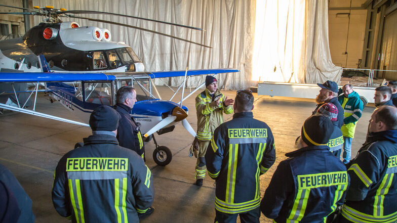 Martin Beier von der Flughafen-Feuerwehr Dresden gibt den Kameraden der drei beteiligten Feuerwehren eine Einweisung, welche Gefahren bei Einsätzen an Großflugzeugen zu beachten sind.