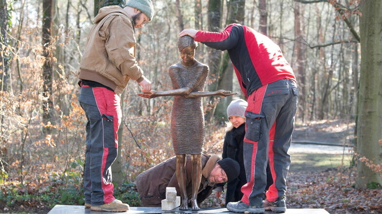 Die Kunstgießer Wilhelm (l.) und Thomas Ihle hieven die Bronzefigur auf ihre Podest. Klaus Zimmerling und Bildhauerin Małgorzata Chodakowska achten auf die Justierung der Füße.