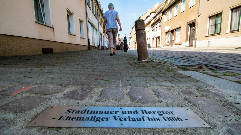 In der Nossener Straße in Roßwein haben Mitarbeiter des Bauhofes mit einer Platte im Gehwegpflaster den weiteren Verlauf der Stadtmauer veranschaulicht.