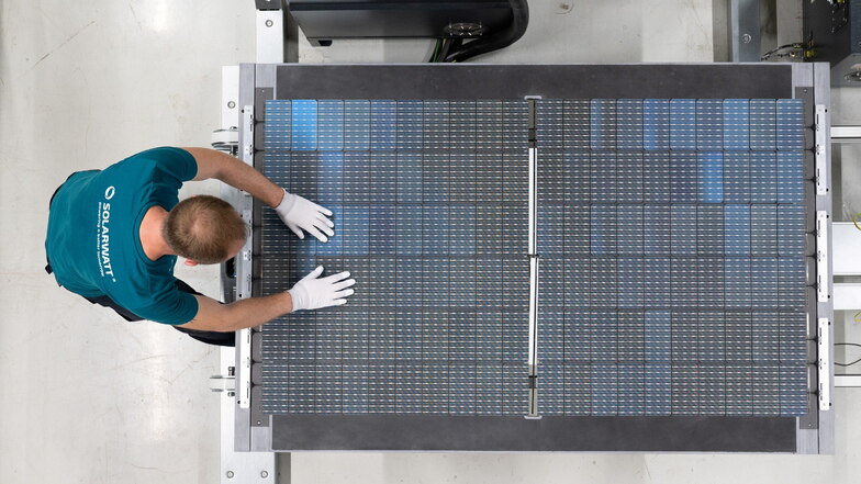 Der stellvertretende Schichtleiter inspiziert in der Produktion der Solarwatt GmbH ein Solarmodul.