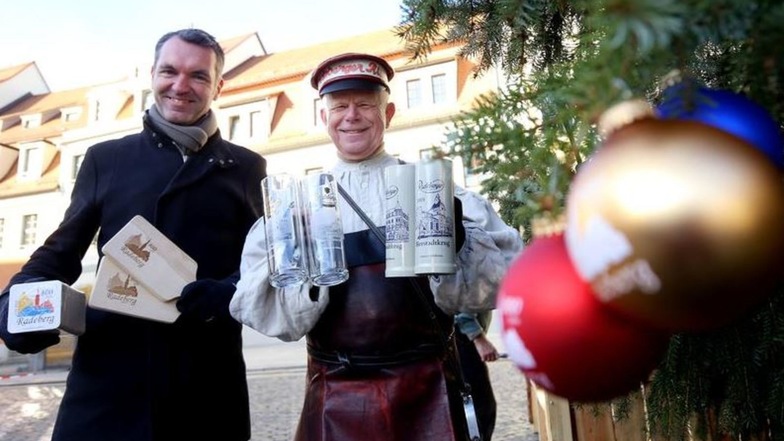 Keine Weihnachtsmänner aber trotzdem Geschenke im Gepäck: Marco Wagner von der Radeberger Stadtverwaltung und Bierkutscher Ernst zeigen Präsente, die auf dem Weihnachtsmarkt in Radeberg angeboten werden. Das sind unter anderem Sammlerstücke wie Bierseidel