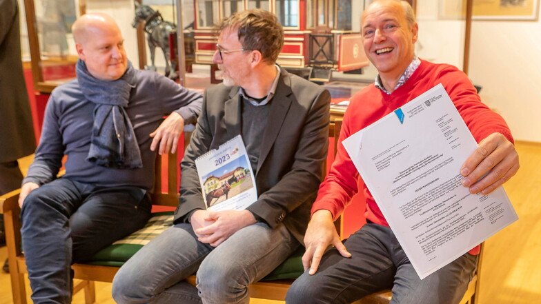 Wichtiges Papier: Vereinschef Jörg Lippert (rechts) hält lachend den Bewilligungsbescheid in die Kamera, den der Landtagsabgeordnete Henning Homann (links) und Stephan Berger vom Wirtschaftsministerium gebracht haben.