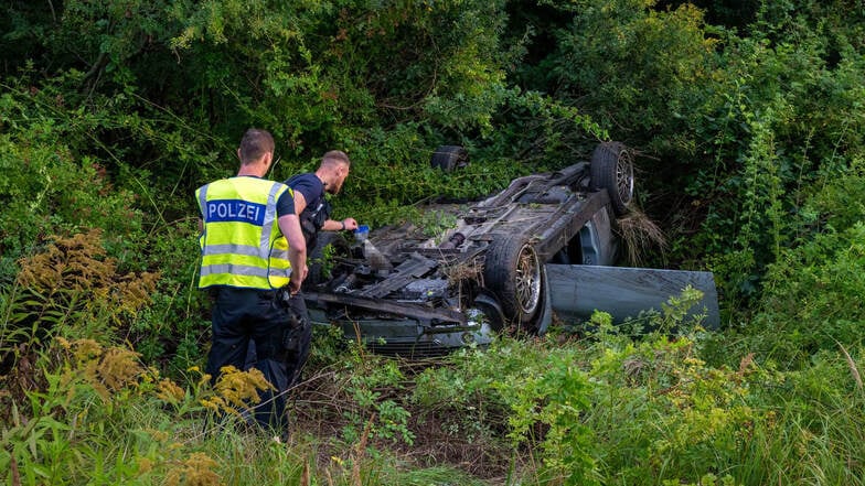 Ein Auto liegt nach einem Unfall auf der B99 bei Zittau überschlagen im Seitengraben.