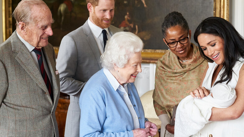 Herzogin Meghan (r) zeigt zusammen mit Prinz Harry (2.v.l) ihren Sohn Archie Harrison Mountbatten-Windsor dessen Uroma Königin Elizabeth II. (M), dem Herzog von Edinburgh (l) und ihrer Mutter, Doria Ragland (2.v.r).