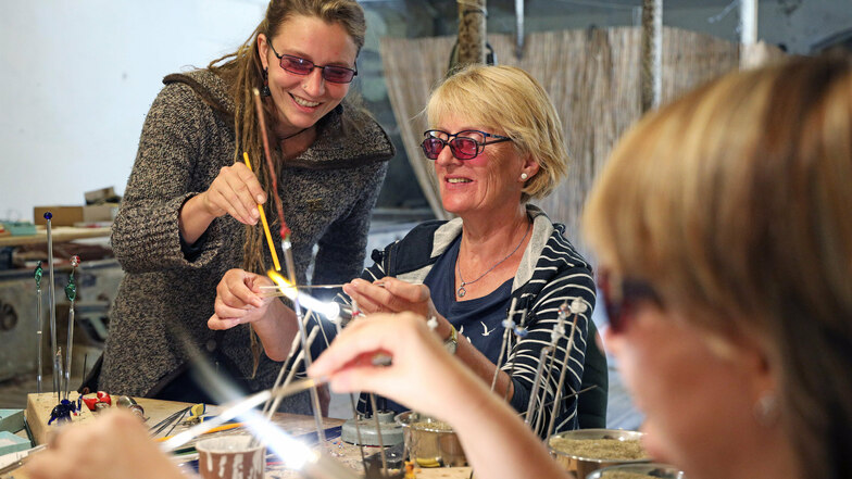 Kursleiterin Henriette Preuß (l.) zeigt Teilnehmerin Barbara Heinrich verschiedene Kniffe, um heißes Glas per Brenner in Form zu bringen. Den Glaskunstkurs gab es dieses Jahr bei der Sommerakademie zum ersten Mal.