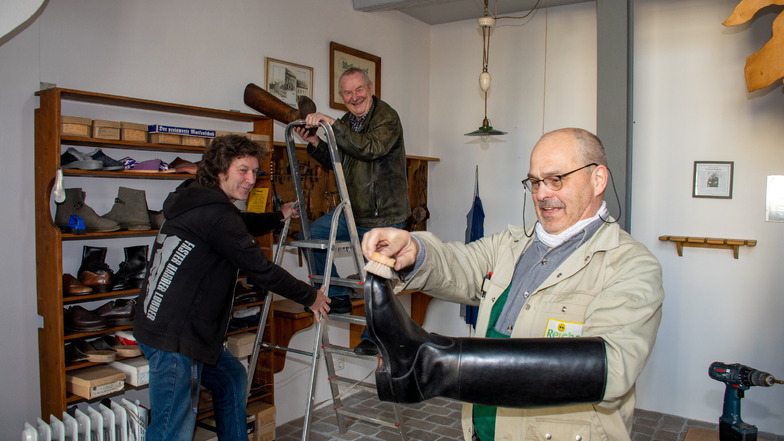 Frank Geißler, Rolf Neidhardt und Uwe Reichel (von links) haben sichtlich Spaß beim Wiedereinrichten des Stiefelmuseums auf dem Leisniger Burglehn. Die Kur des großen Stiefels hat die Kommune genutzt, um den Raum vorzurichten.