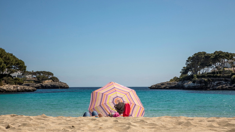 Zwei Mensch liegen an einem Strand auf Mallorca.