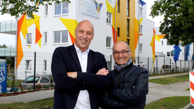 Bernd Nickler (links) und Jens Nixdorf sind Geschäftspartner in der Firma GAtAS, die am neuen Hoyerswerdaer Oberschulzentrum sowie an der Wohnanlage „Cocoon Living“ (hier im Hintergrund zu sehen) entscheidend mitgewirkt hat.