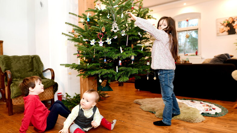 Die sechsjährige Gerda schmückt schon den Weihnachtsbaum. Ihre Brüder Hans-Egard und Edgar schauen zu.