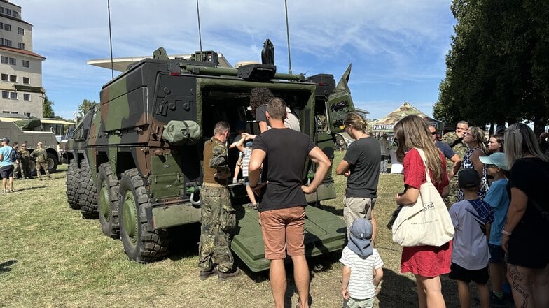 Familien schauen sich auf dem Stadtfest den Panzer auf der "Blaulichtmeile" an.