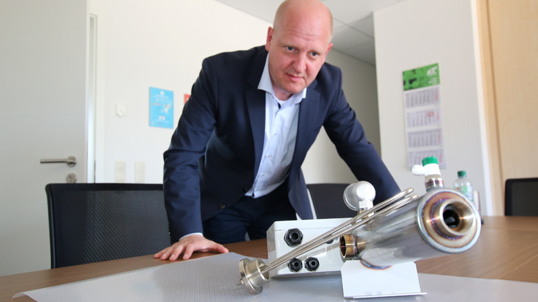 Der Landtagsabgeordnete Henning Homann schaut sich einen elektrischen Durchlauferhitzer für Wärmepumpen an, der bei der Döbeln Elektrowärme GmbH hergestellt wird.