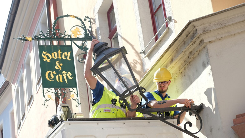 Mitarbeiter der Stadtwerke Meißen installieren eine LED-Leuchte in der Fleischergasse in Meißen.