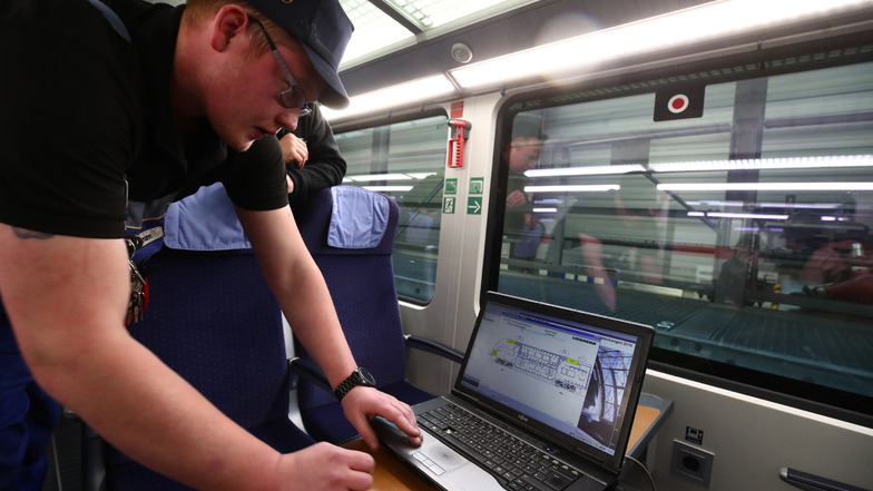 Markus Aßmann überprüft an einem Laptop die Heizungsanlage in einem IC Zug im ICE Werk Leipzig bei der Inspektion und Wintervorbereitung. 