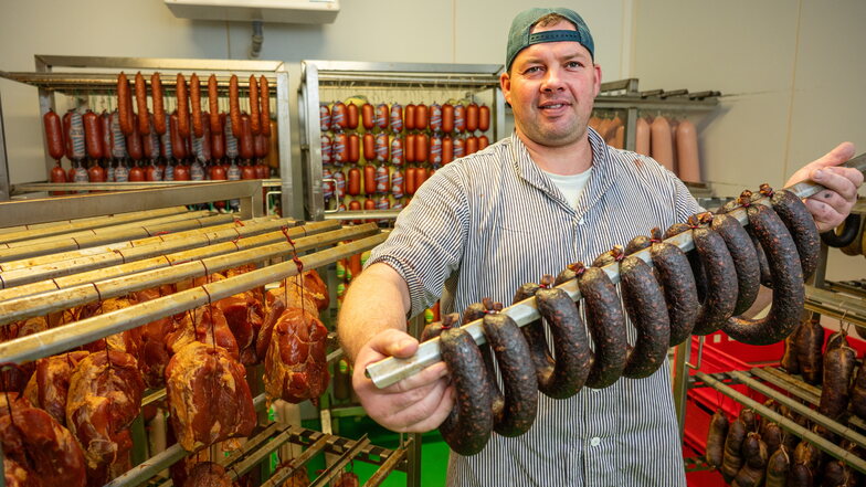 Markus Probst, einer von acht Mitarbeitern in der Fleischerei Cannewitz, hat die kürzlich ausgezeichnete Pfefferbeißer vom Bison kreiert und zeigt hier andere Produkte der Firma.