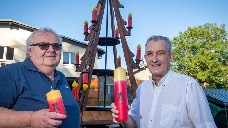 Wolfgang Vogel vom Verschönerungsverein (links) und Matthias Poch, Geschäftsführer der DDV Döbeln GmbH, mit den Kerzen, die ab morgen zugunsten der Pyramiden-Reparatur verkauft werden.