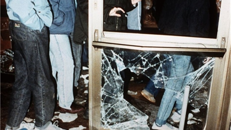 Das Archivbild vom 15.01.1990 zeigt DDR-Bürger, die durch eine zerstörte Tür das ehemalige Amt für Nationale Sicherheit im Ostberliner Stadtteil Lichtenberg betreten, nachdem es bei einer Demonstration von aufgebrachten Bürgern gestürmt wurde.