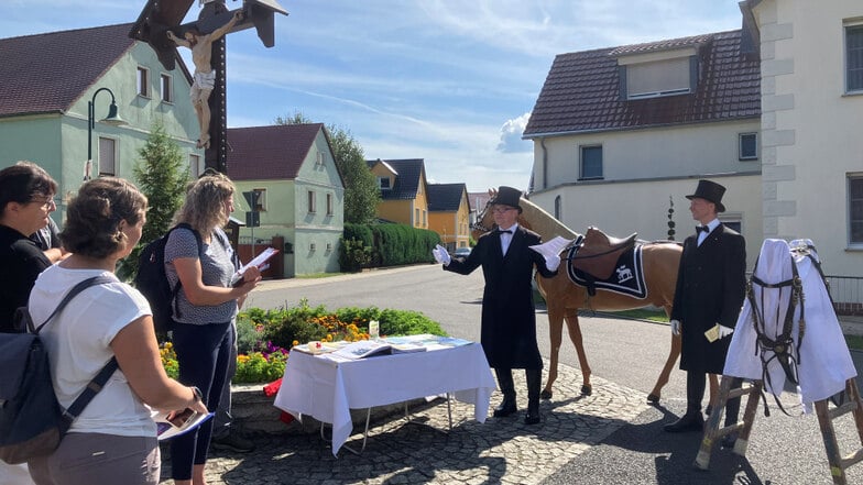 Teilnehmer der Osterprozession stehen am Sollschwitzer Kreuz mitten im Dorf. Eine Chronik zeigt seit 1984, wer Jahr für Jahr bei der Prozession dabei war. Am Kreuz gibt es unter anderem auch das Singen der Mädchen in der Fastenzeit.