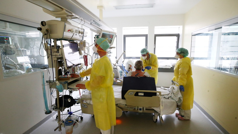Ärzte und Pfleger untersuchen einen Patienten auf der Covid 19 Intensivstation im SRH Waldklinikum in Gera.