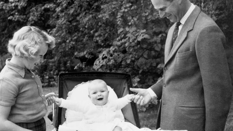 1960: Philip (r) und Prinzessin Anne (l) halten die Hände von Prinz Andrew, der in einem Kinderwagen sitzt.