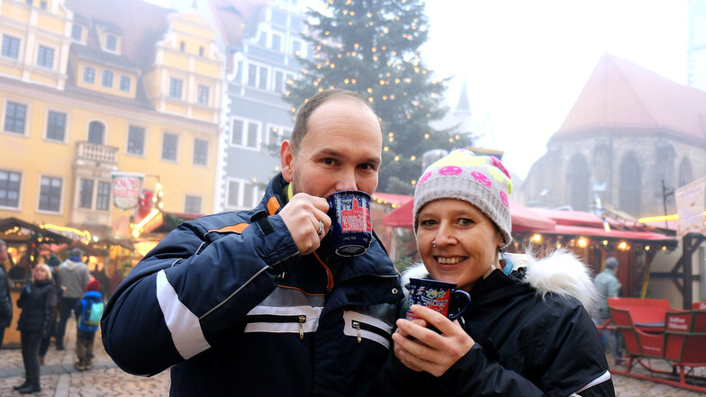 Ließen sich am Montag die Vorweihnachtslaune nicht durch den dicken Nebel über der Stadt verderben: Romy und Marcus Kuhnt haben schon einmal probiert, wie dieses Jahr die Meißner Weihnacht aus der neuen Meißner Tasse schmeckt.