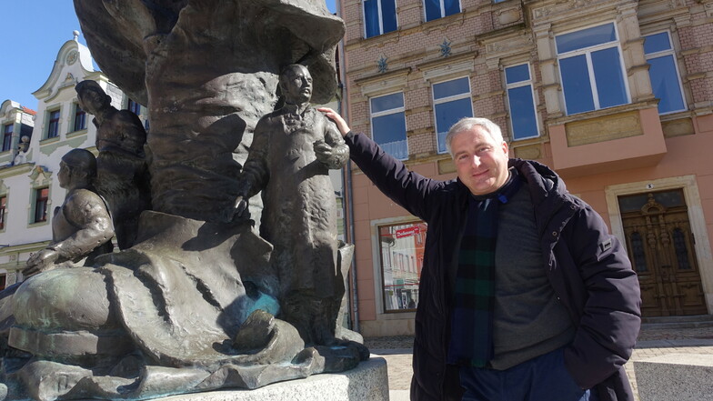 Der Leipziger Danilo Art-Merbitz am Stiefelbrunnen vor dem Haus, in dem er den fiktiven Helden seiner Geschichte arbeiten lässt. Der Roman, den der Leipziger schreibt, spielt in Döbeln.