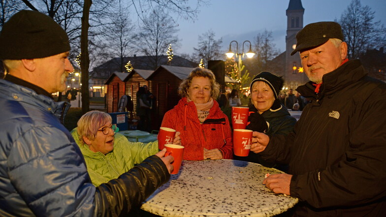 Diese Nieskyer freuen sich, zusammen auf dem Weihnachtsmarkt zu stehen und Glühwein aus der roten Niesky-Tasse zu trinken.