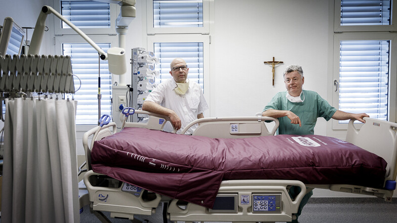 Die Chefärzte Dr. Jörg Lubrich (links) und Dr. Uwe Treue stehen auf der Isolierstation an einem Bett, welches speziell für Beatmungspatienten bestimmt ist.