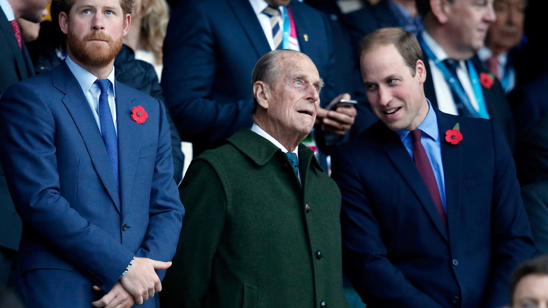Prinz Harry (l) und sein Bruder Prinz William (r) mit ihrem Großvater Prinz Philip bei einem Rugby-Spiel im Mai 2015. Anlässlich der Beisetzung von Prinz Philip kommt es nun wohl zum Wiedersehen von Harry mit der royalen Familie.