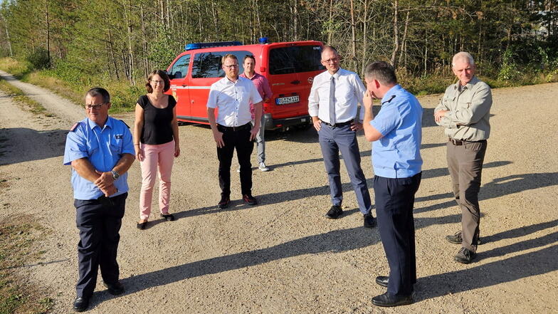 Bürgermeister Dr. Mirko Pollmer (3. v. l.) und Landrat Ralf Hänsel (3. v. r.) mit Vertretern der Feuerwehr und des Sachsenforsts in der Gohrischheide.