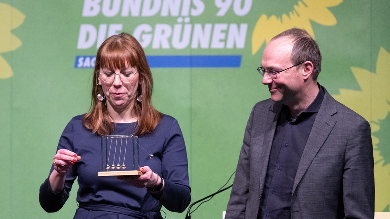 Katja Meier, Justizministerin von Sachsen, und Wolfram Günther (beide Bündnis90/Die Grünen), Umweltminister von Sachsen, stehen mit einem Newton-Pendel auf dem Landesparteitag ihrer Partei in der Stadthalle Krone auf der Bühne.