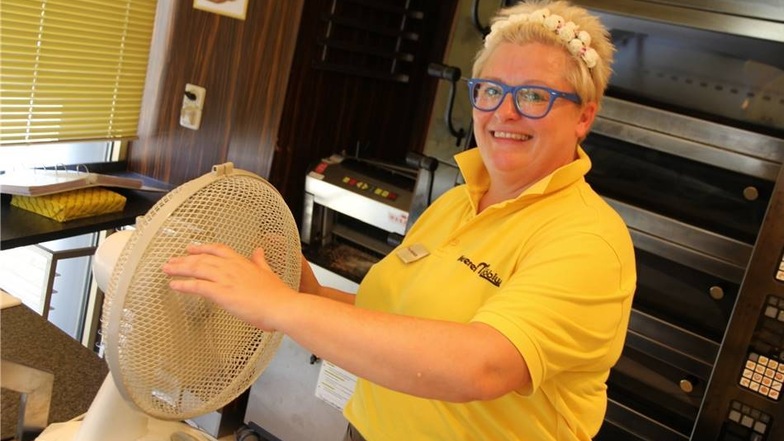 Claudia Mühlfeld von der Bäckerei-Filiale Möbius kühlt sich am Ventilator ab.