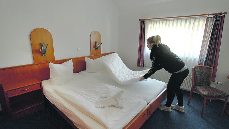 Gut schlafen in der Börse. Kathleen Apel schüttelt in einem der sechs Zimmer des Coswiger Hotels die Betten auf.
