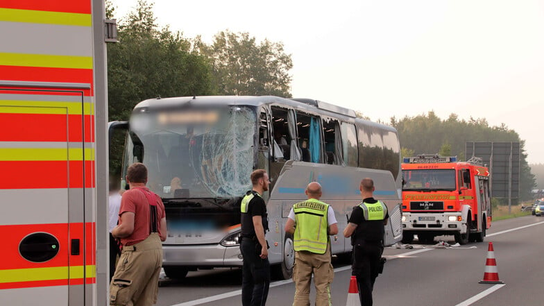 Rettungskräfte stehen neben einem verunfallten Reisebus auf der Autobahn 24.