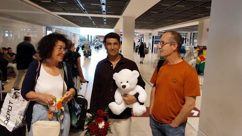 Gulbadin Nazari (M.) und ihn Unterstützende warten am Flughafen BER auf die Ankunft seiner Frau und Tochter.