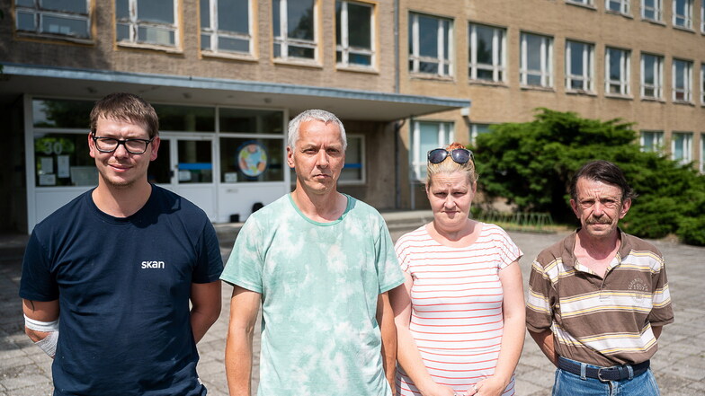 André Knobloch (2.v.l.) zusammen mit seiner Frau (2.v.r.) und anderen betroffenen Eltern vor der ehemaligen Schule in der Erich-Weinert-Straße, wo die „Kleinen Weltentdecker“ untergebracht sind.
