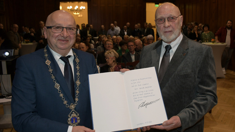 Albrecht Bergmann (rechts) und Bürgermeister Steffen Ernst (FDP) zeigen das Goldene Buch der Stadt Waldheim, in das sich Bergmann zuvor eingetragen hat.